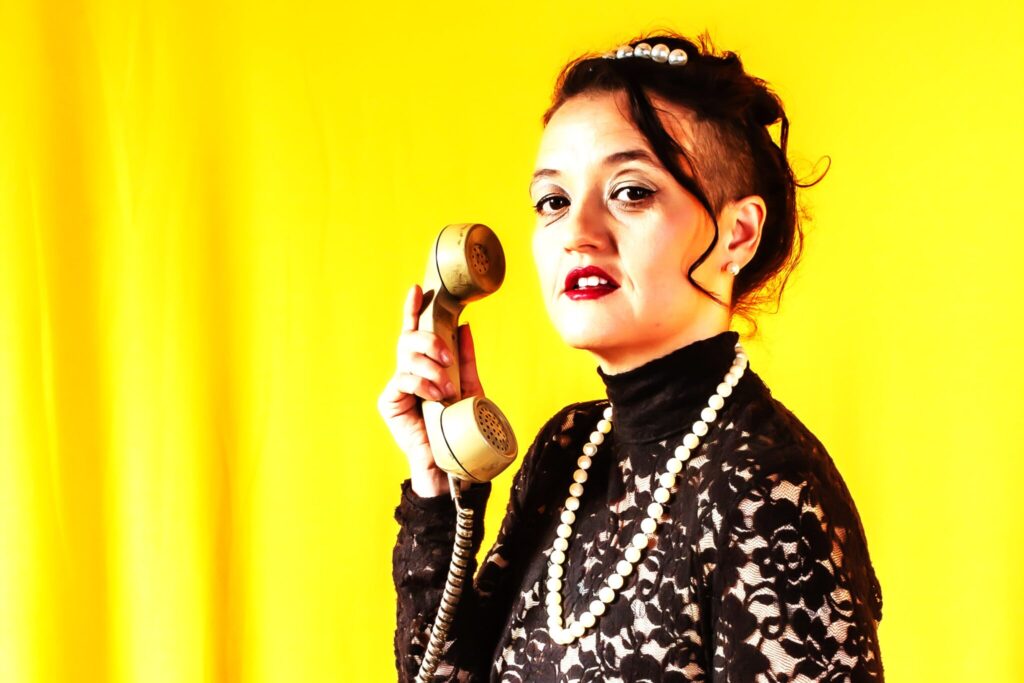 La Charawilla con teléfono retro, peinado audaz y perlas. Lanza boleros originales "Cuando el alma se me escapa por la boca".