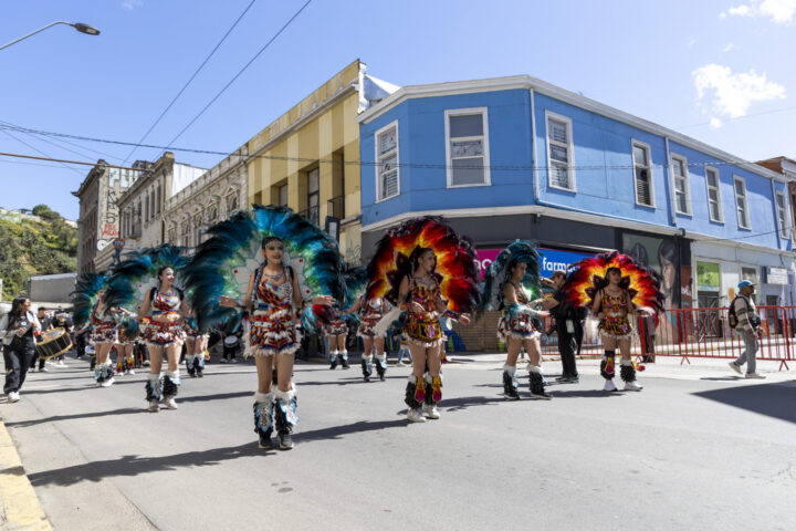 Bailarinas con trajes de plumas y colores en el Carnaval Mil Tambores de Valparaíso, Chile. Ocupación hotelera al 100%.