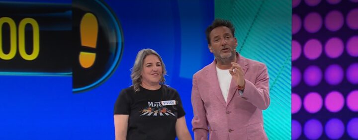 Participante Vivian y presentador en el programa 'Ahora Caigo' durante el juego final, con un marcador visible en el fondo.