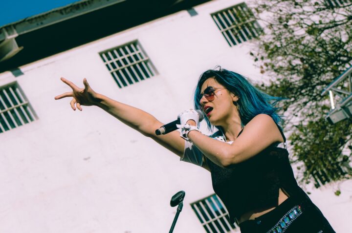 Ángel Galab, pelo azul y gafas de sol, canta en concierto. Presenta su álbum Corazón en vivo. Rock, anisong.