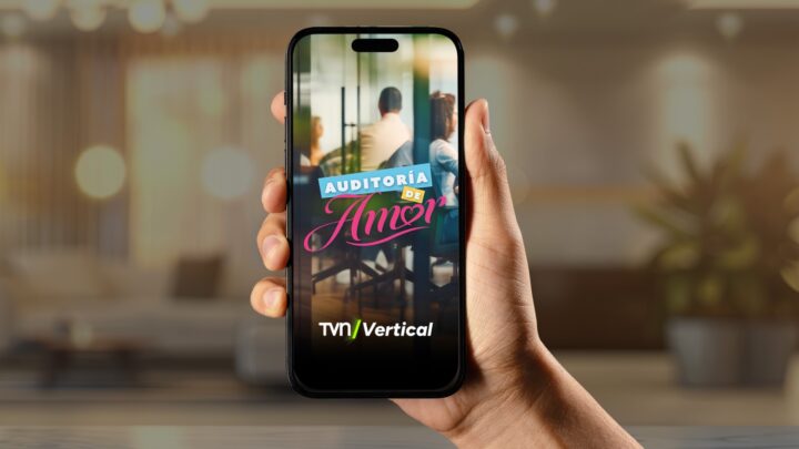 Mano sostiene smartphone con "AUDITORÍA DE AMOR", personas en pantalla y logo TVN/Vertical. Streaming.