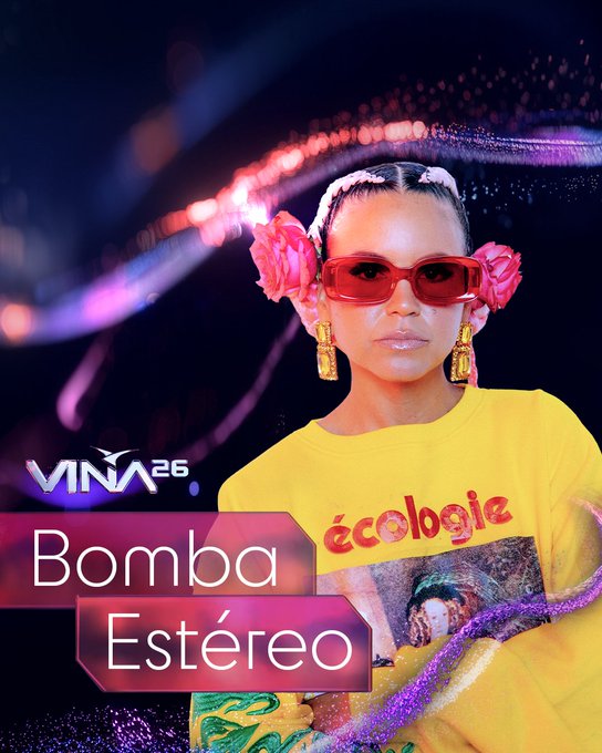 Bomba Estéreo en Viña 2026. Liliana Saumet con gafas rojas, flores en el cabello y camiseta amarilla.