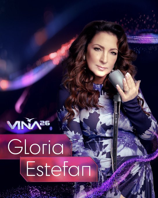 Gloria Estefan, artista confirmada para Viña 2026, con micrófono y vestido floral. Festival Latino más grande del mundo.