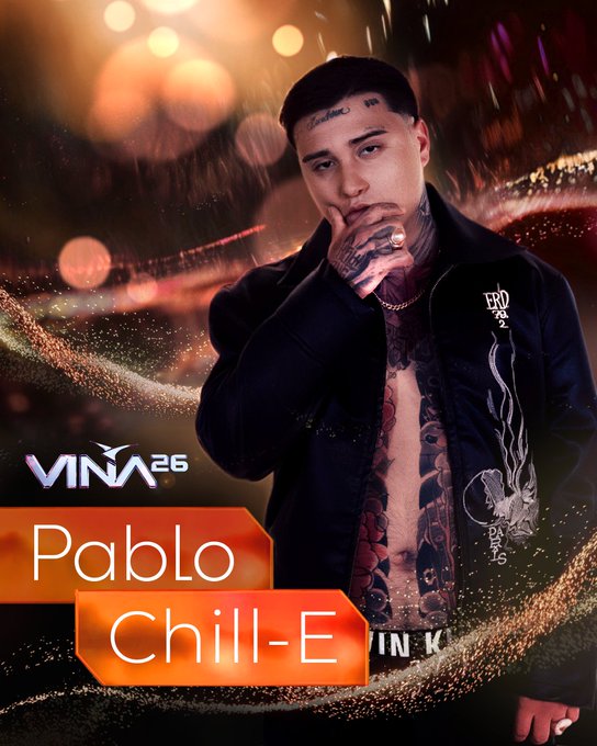 Pablo Chill-E, artista confirmado para Viña 2026. Rapper con tatuajes, chaqueta abierta. Fondo de luces festivas.