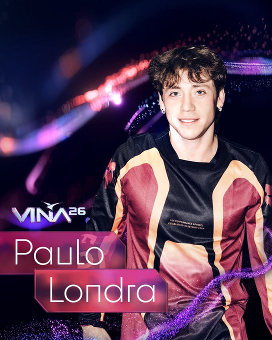 Paulo Londra sonriendo, confirmado para Viña 2026. Viste camiseta deportiva. Fondo con luces de escenario y logo del festival.